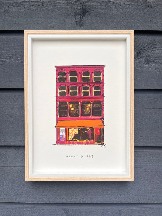 Night and Day venue in Manchester art print, framed in a light wooden frame hung on a wooden dark grey panelled wall