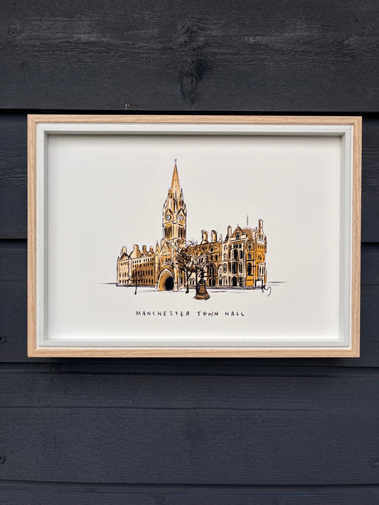 Manchester town hall illustrated art print, framed in a light wooden frame hung on a wooden dark grey panelled wall