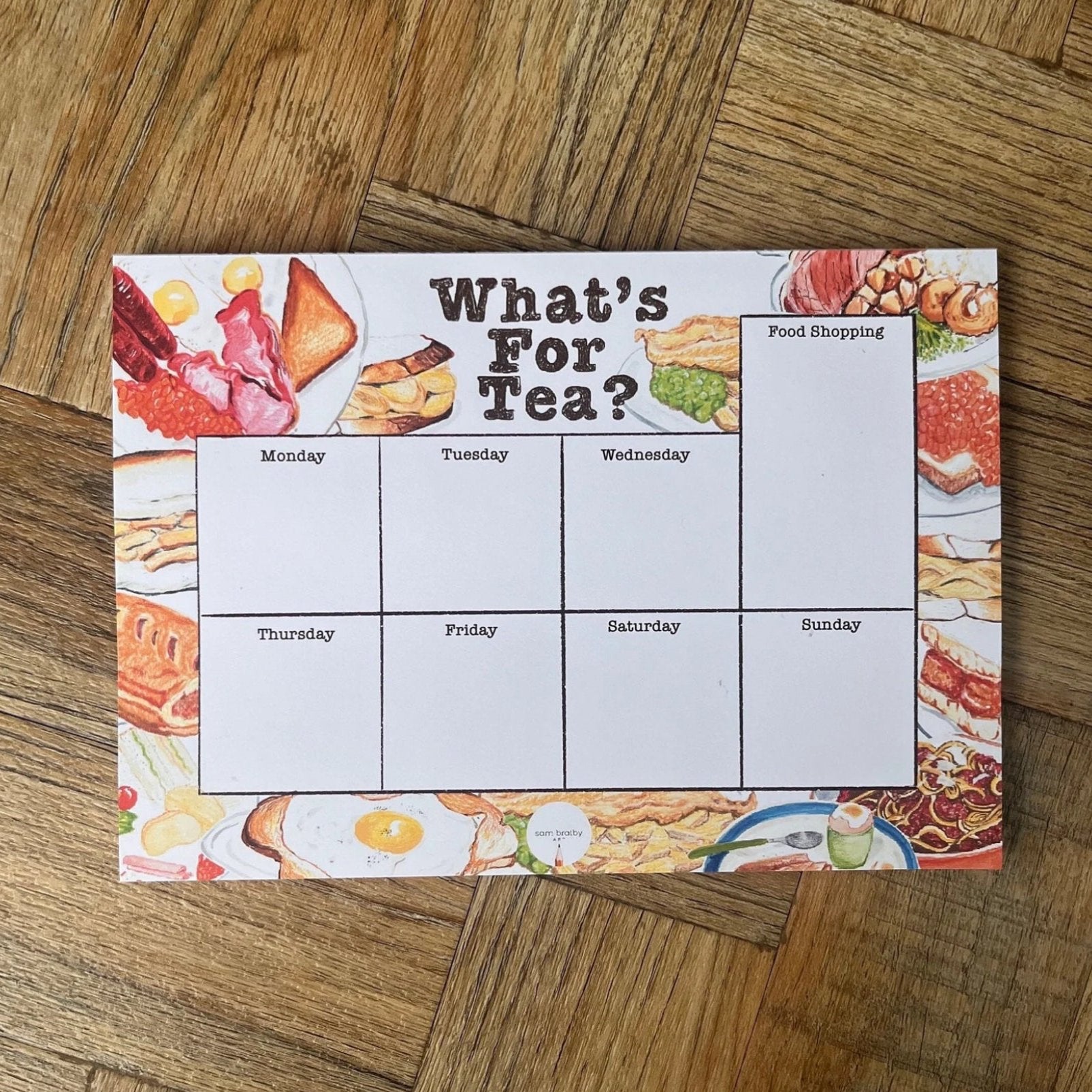 What’s for tea planner pad illustrated with a variety of meals including breakfasts and chip butties. On top 7 ays sections and  food shop ping list it the left of the calendar 